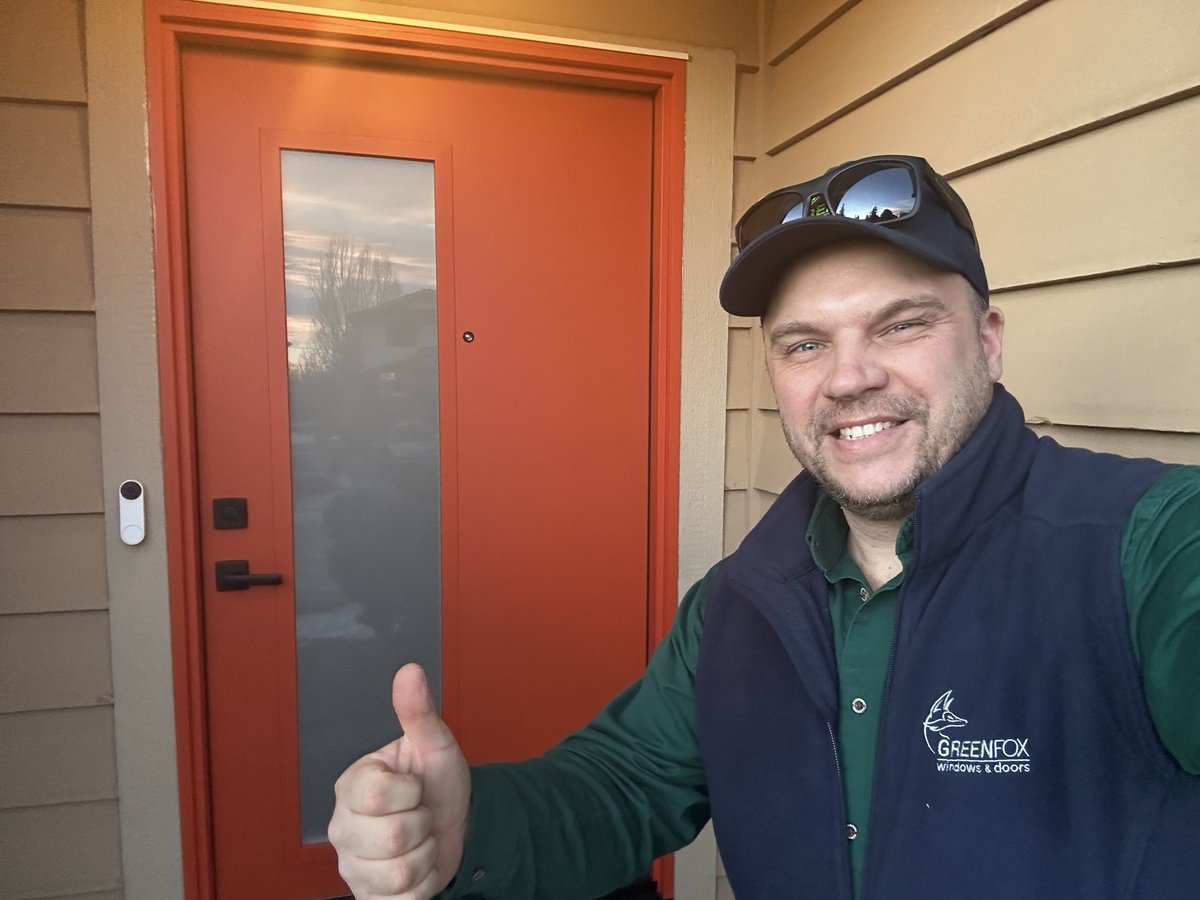 Adam Zinkovskyy, GreenFox project manager, next to a freshly installed front door