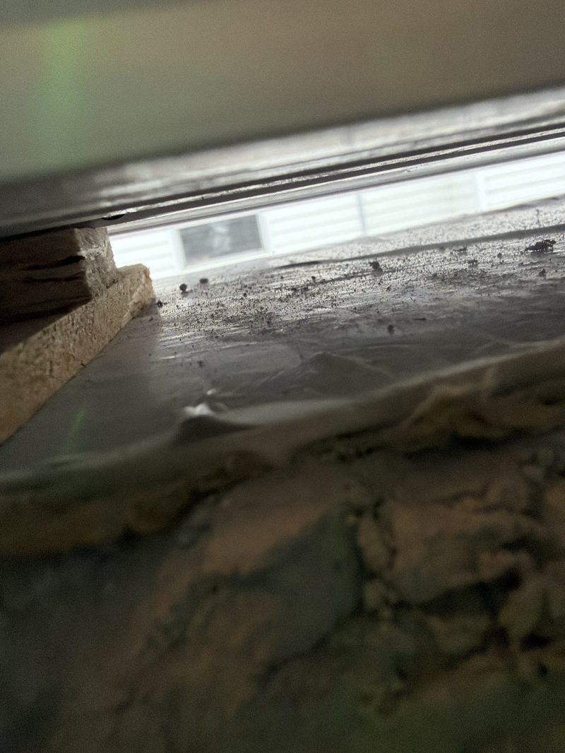 Completed waterproofing installation showing interior foam seal and shim placement