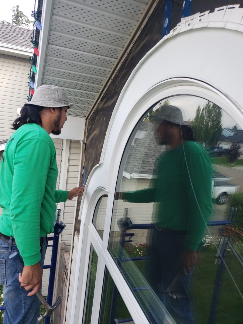 Installer fitting arched window from exterior