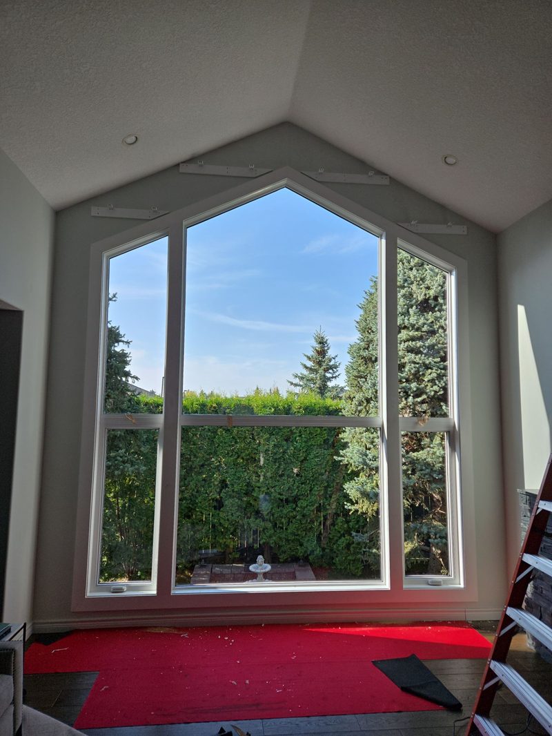 Kitchen counters and appliances fully draped with protective plastic before window work